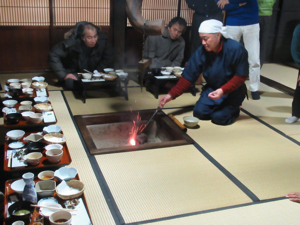 旅先で囲炉裏を囲む交流の様子